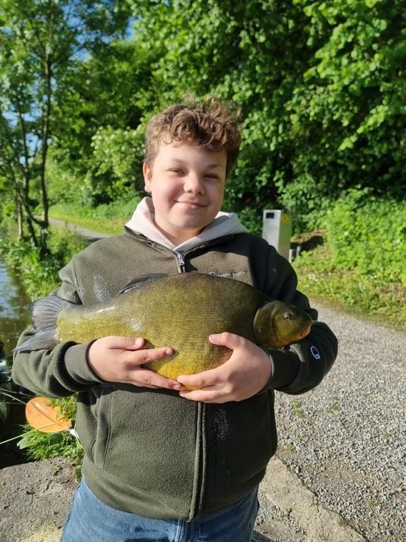 Jungfischer, der einen Fisch hält